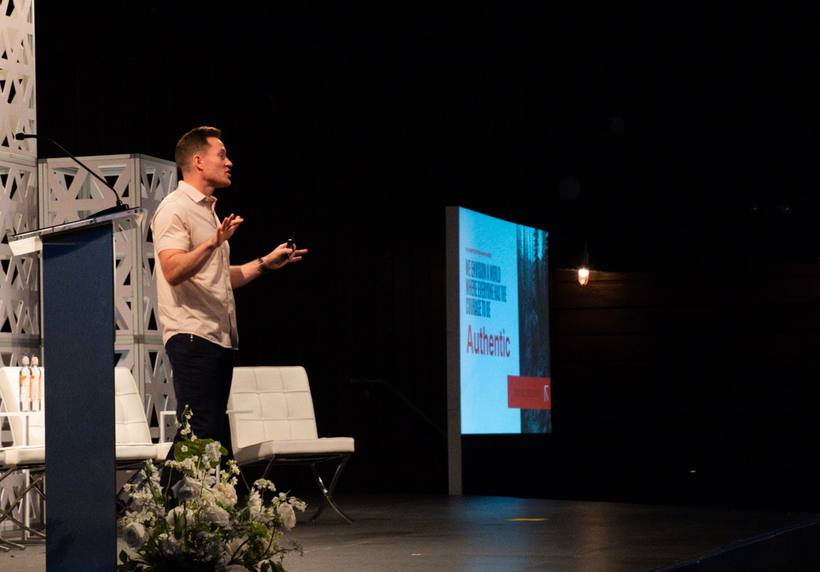 Jacob speaking on stage with the word Authentic on screen